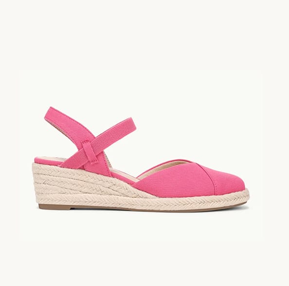 A side view of a bright pink close-toe espadrille with the toe facing right. 
