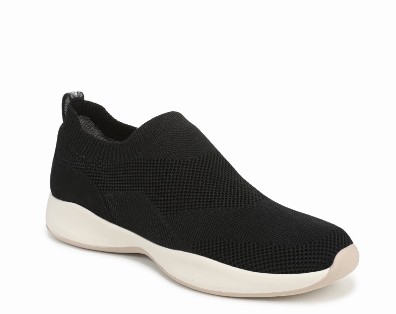 An angled view of a black fabric slip on sneaker with an off-white sole. 