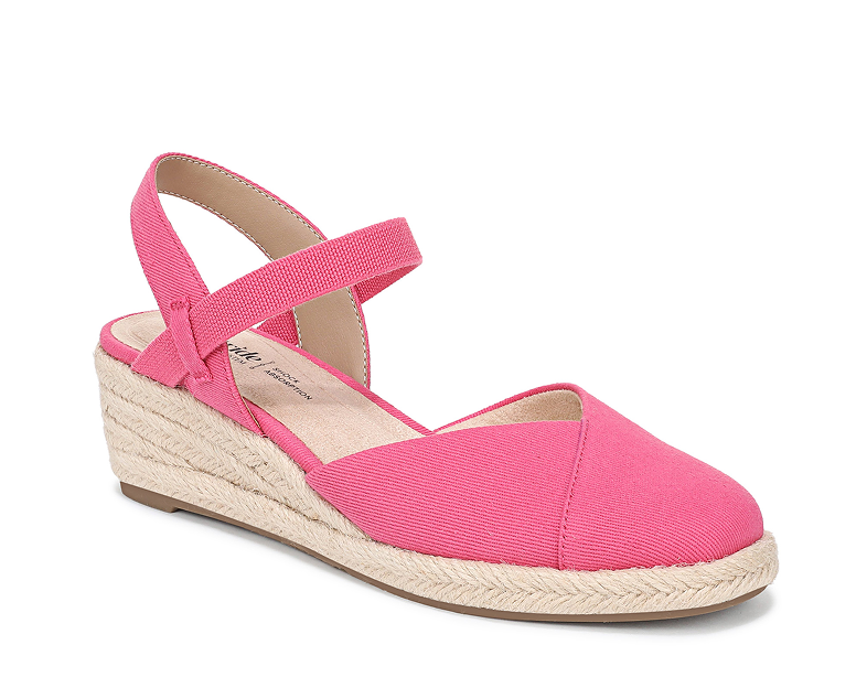 An angled view of a closed-toe espadrille with a bright pink fabric upper. 