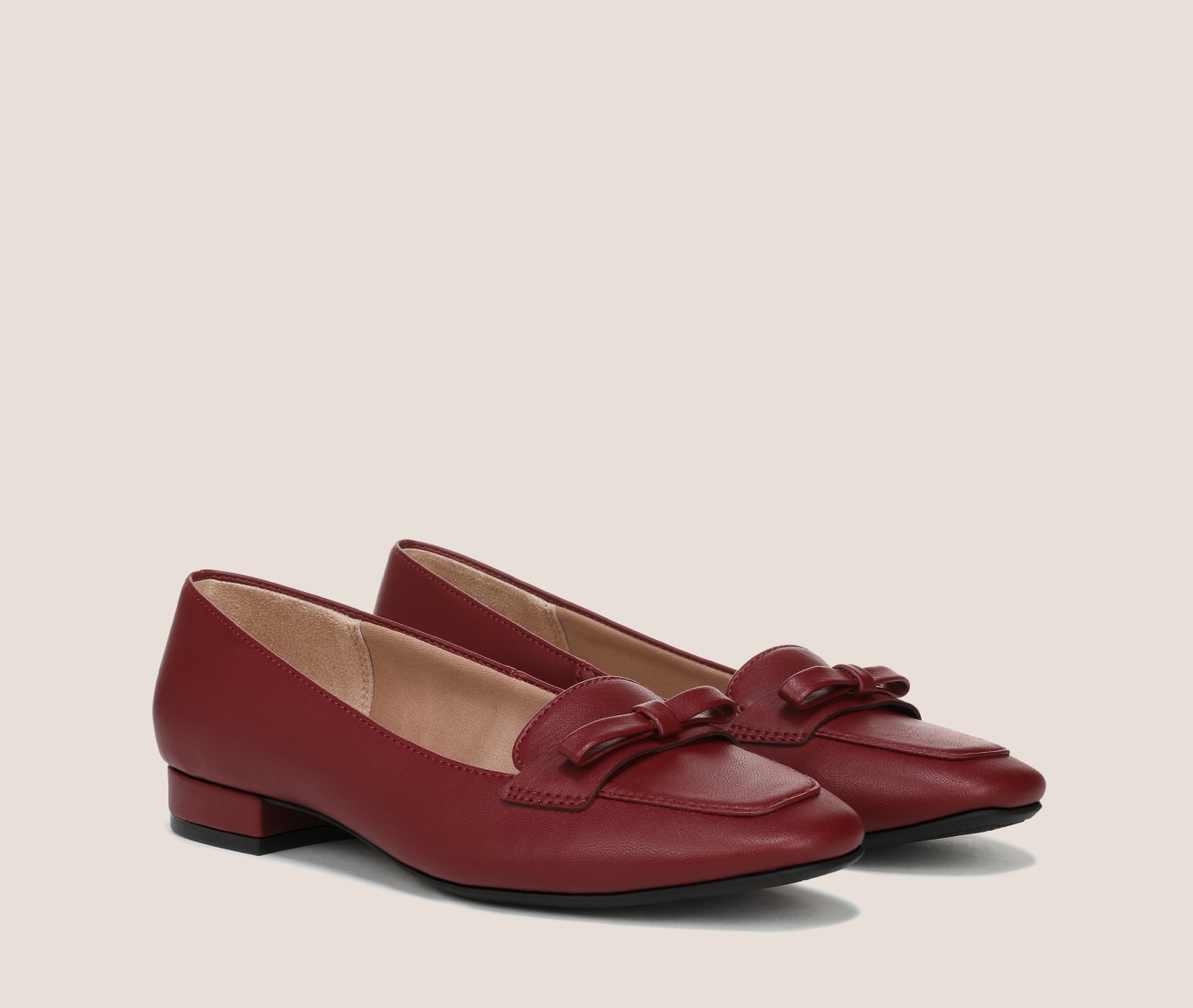 A pair of Claudine loafers with a block heel and bow detail in the color dark cherry red.