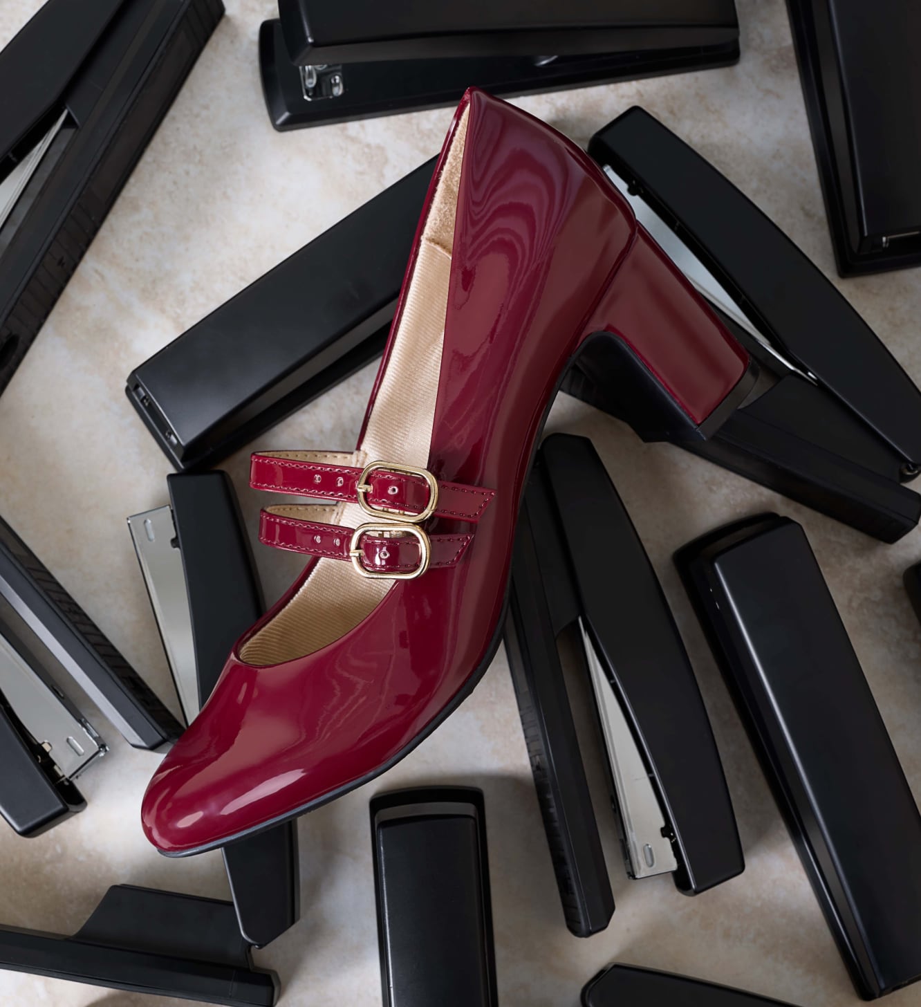 The True mary jane pump with a double straps and a block heel in the color dark cherry red, sitting on a desk.