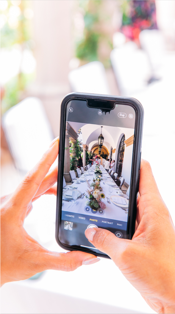 An influencer takes a photo of the table decorations at the Parigi brunch for social media.