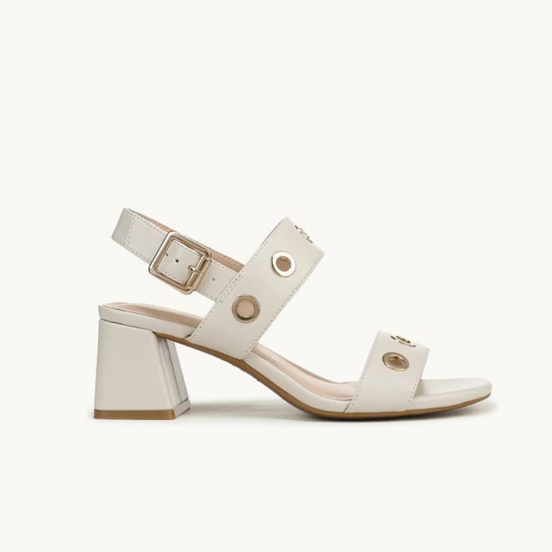 Side view of a women's slingback block heel sandal in white faux leather with gold grommets on the straps.