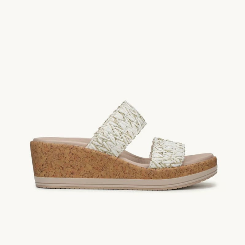 Side view of a women's wedge sandal with a cork bottom and white and gold raffia straps. 