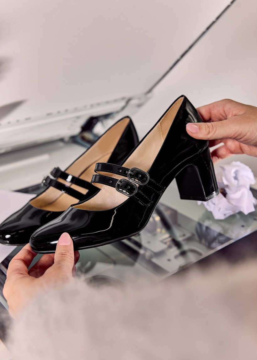 A model holding a pair of LifeStride heels