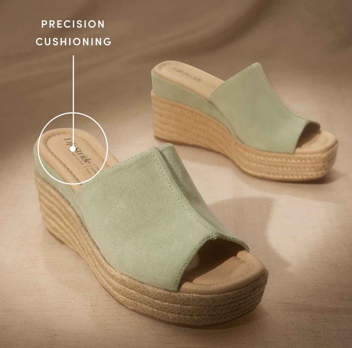 A pair of jade green open-toe espadrilles on a tan background, with text reading “Precision cushioning